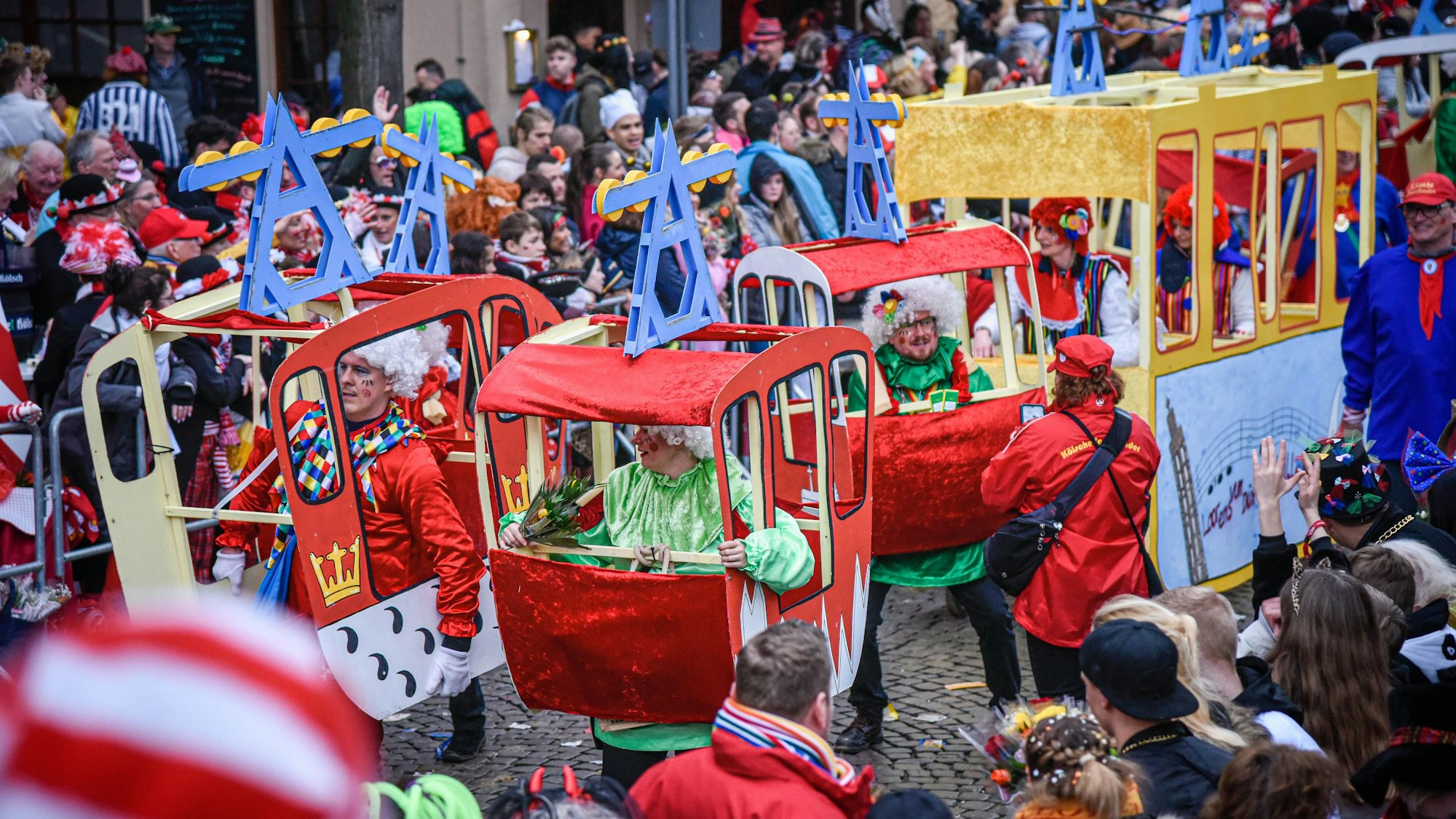 Teilnehmer des Rosenmontagszugs in Köln sind als Seilbahn-Gondeln verkleidet.