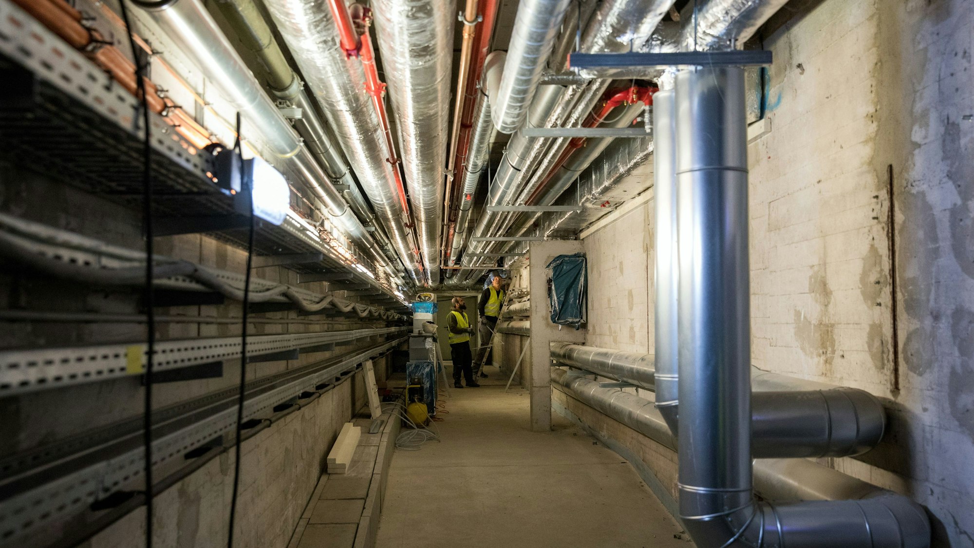 Das Bild zeigt einen Gang im Keller des Operhauses mit Versorgungsleitungen.