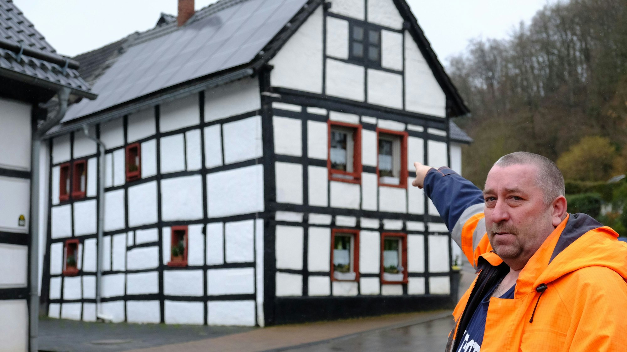 Stephan Grund zeigt auf ein denkmalgeschütztes Haus in Mechernich Eiserfey.