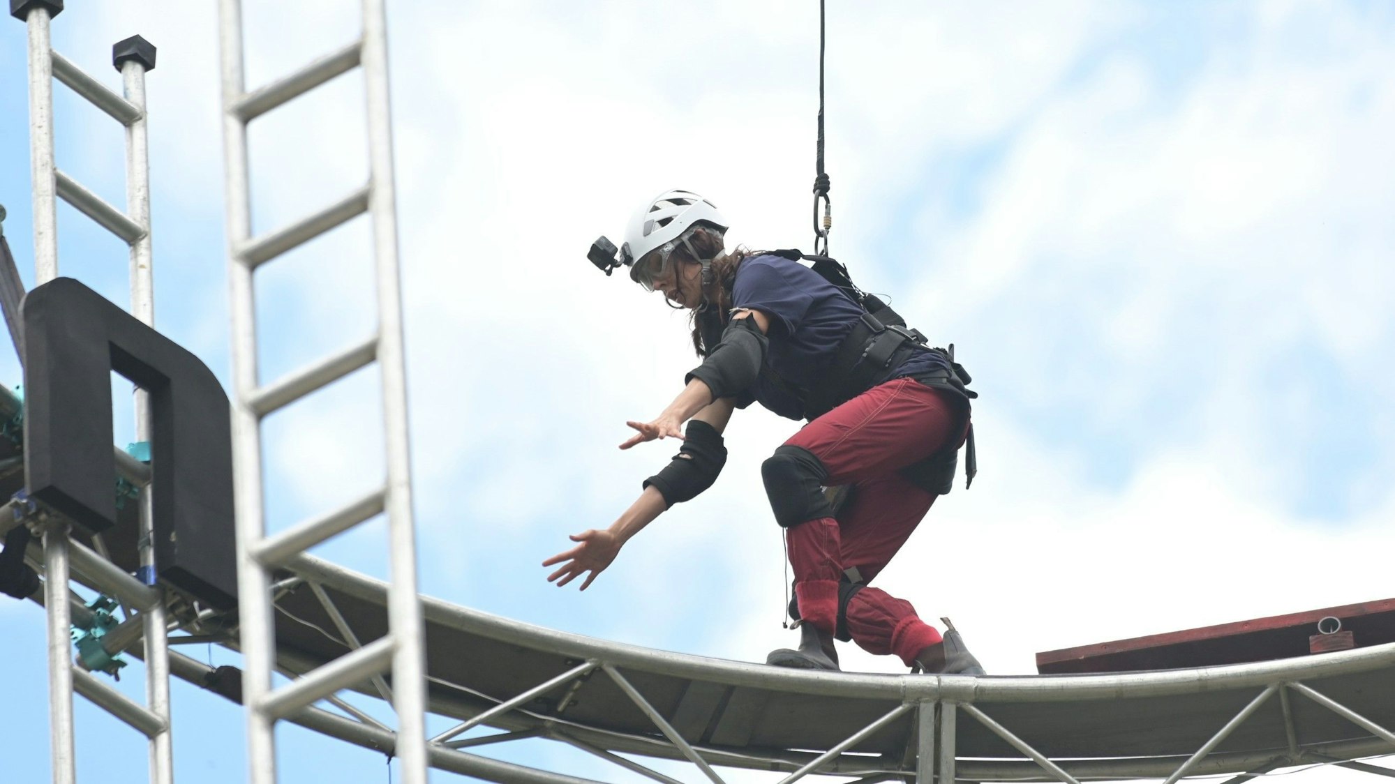 Es ist Jana zu sehen, wie sie auf dem Gerüst-Ring balanciert.