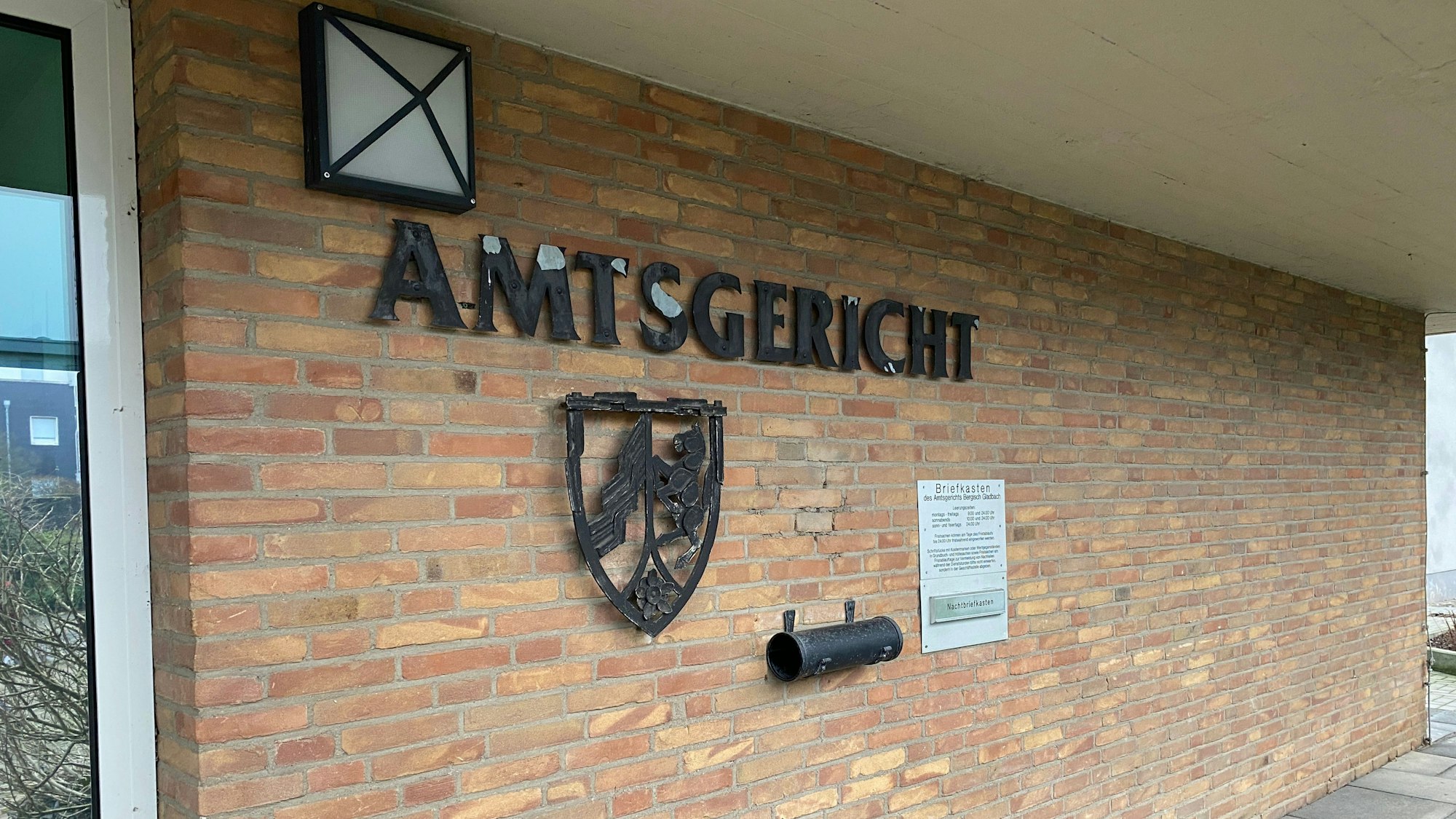 Ein Gebäude mit einer Klinkerwand, darauf der Schriftzug Amtsgericht und ein Wappen.