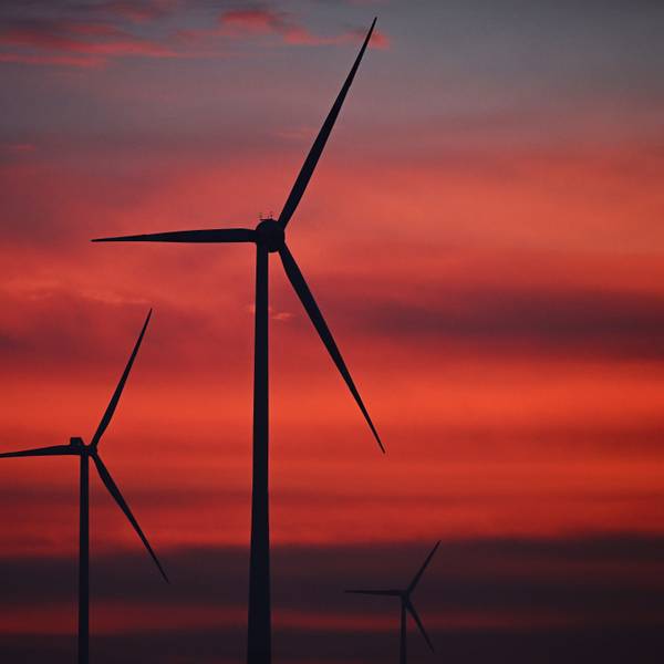 Windräder sind im Windpark Neudorf bei Sonnenaufgang zu sehen.
