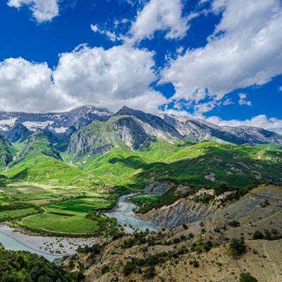 Foto von einem Berg, Blick auf die Vjosë im Vorder- und auf Berge im Hintergrund