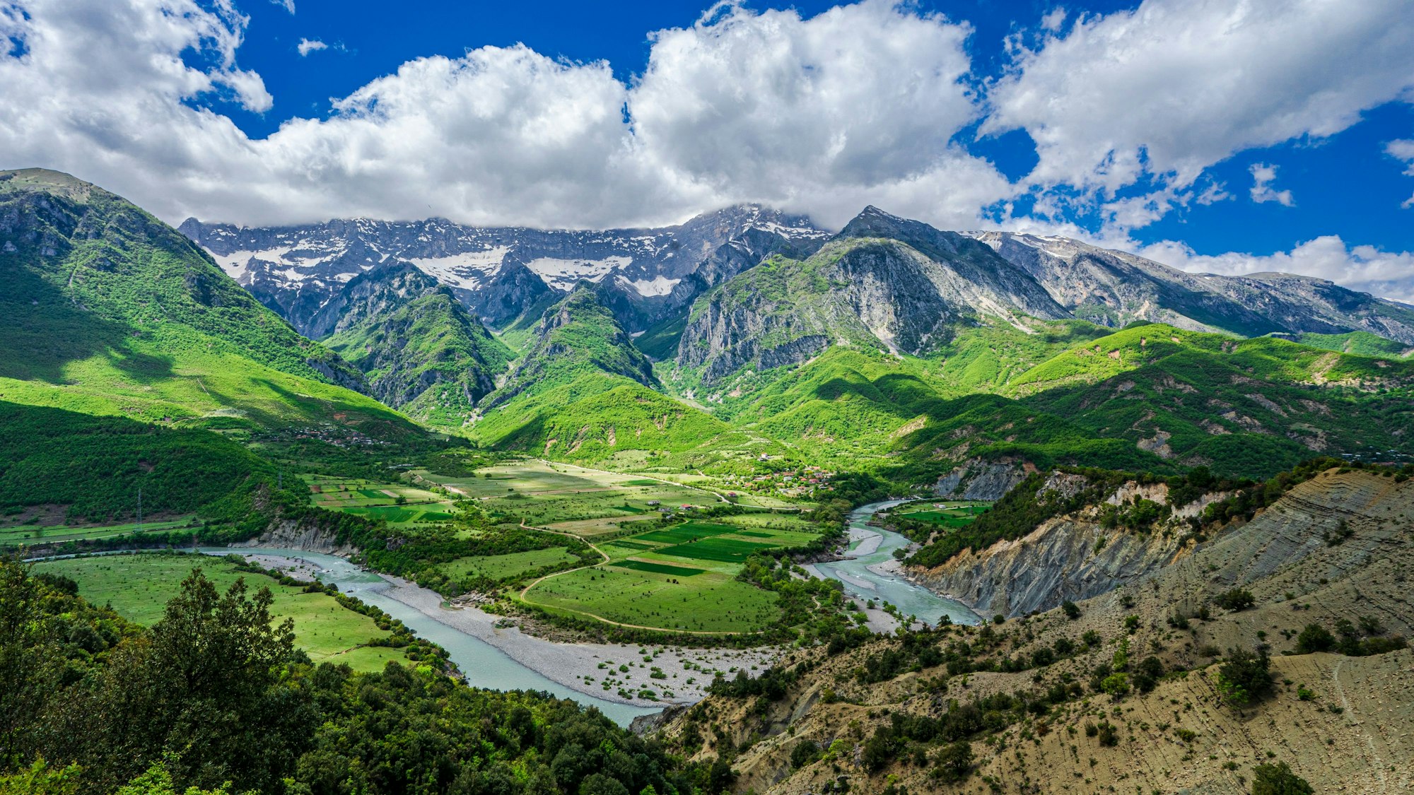 Foto von einem Berg, Blick auf die Vjosë im Vorder- und auf Berge im Hintergrund