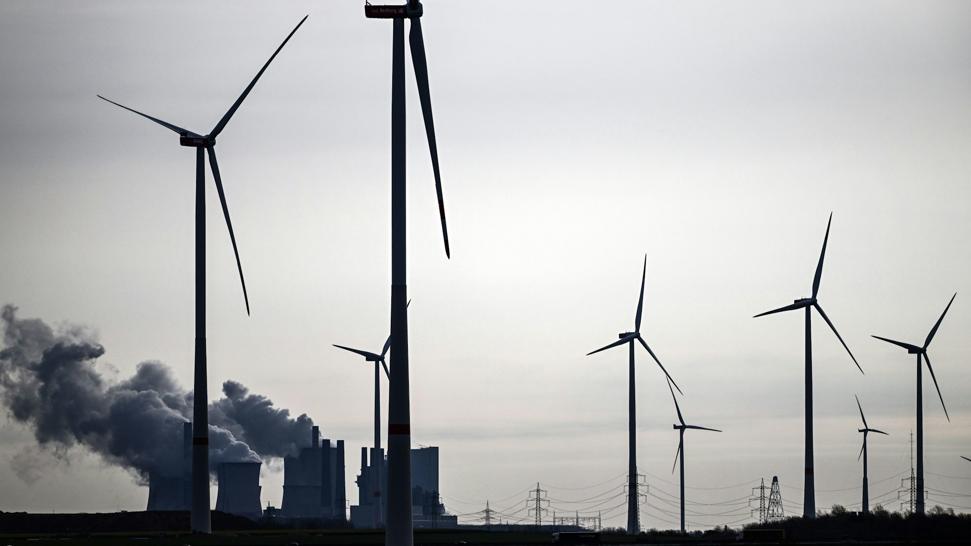 Windräder stehen am Braunkohletagebau Garzweiler, im Hintergrund das Braunkohlekraftwerk Neurath. (Archivbild)