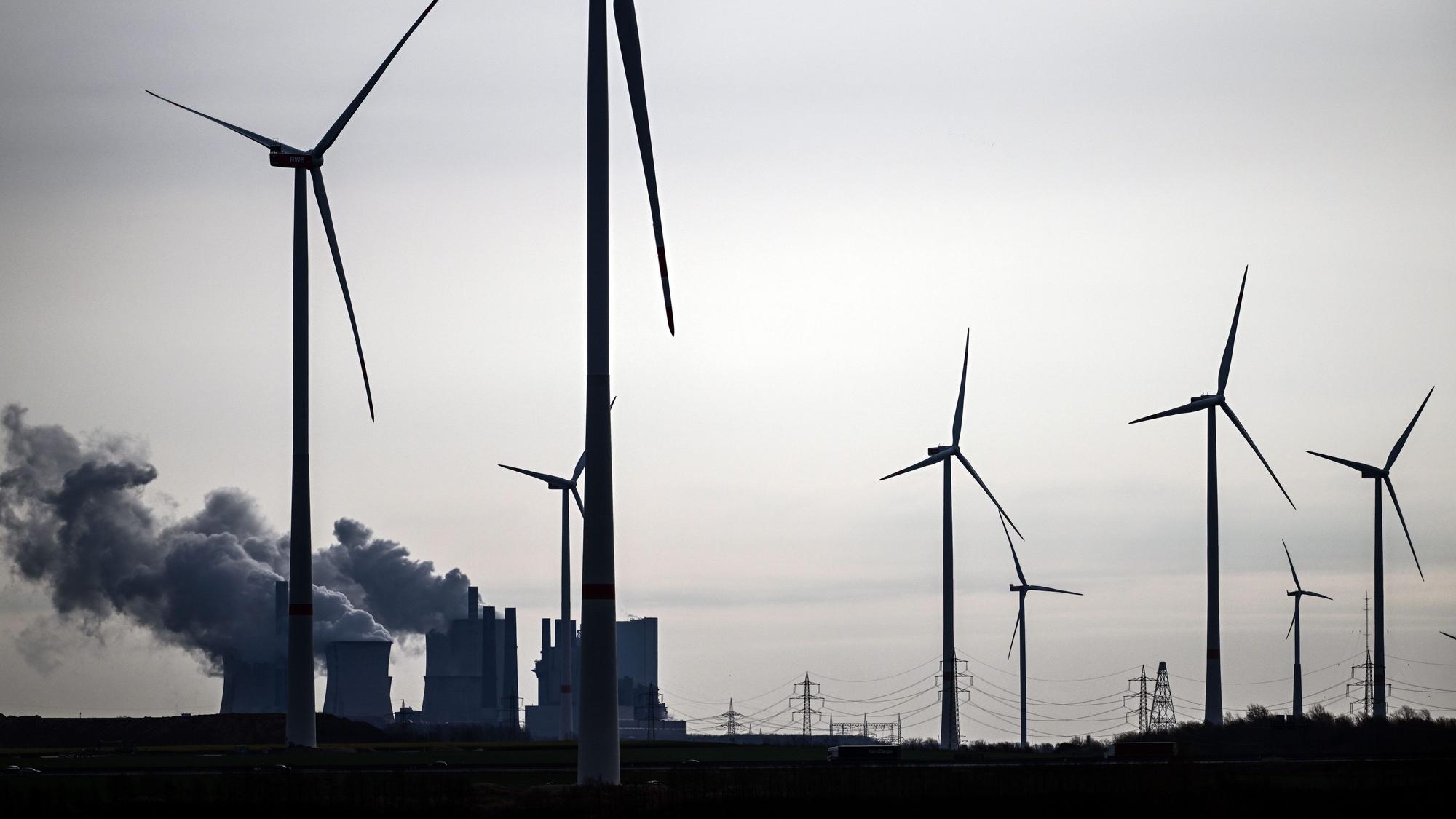 Jackerath: Windräder stehen am Braunkohletagebau Garzweiler, im Hintergrund ist das Braunkohlekraftwerk Neurath zu sehen mit seinen dampfenden Türmen.