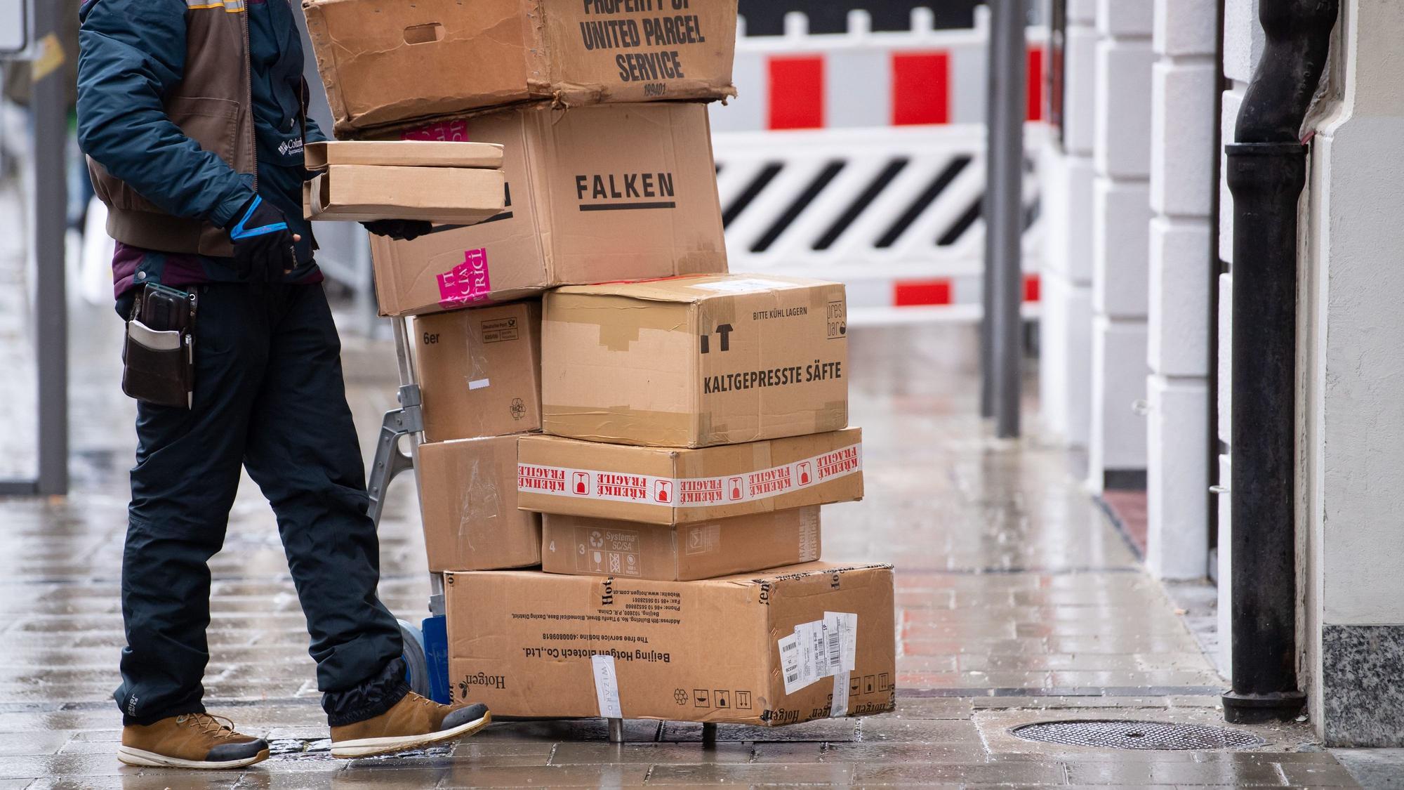 Ein Paketbote liefert in der Innenstadt Pakete aus.
