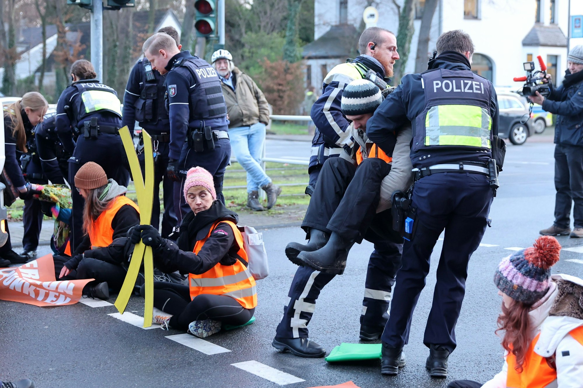 Polizisten tragen die Aktivisten von der Straße.