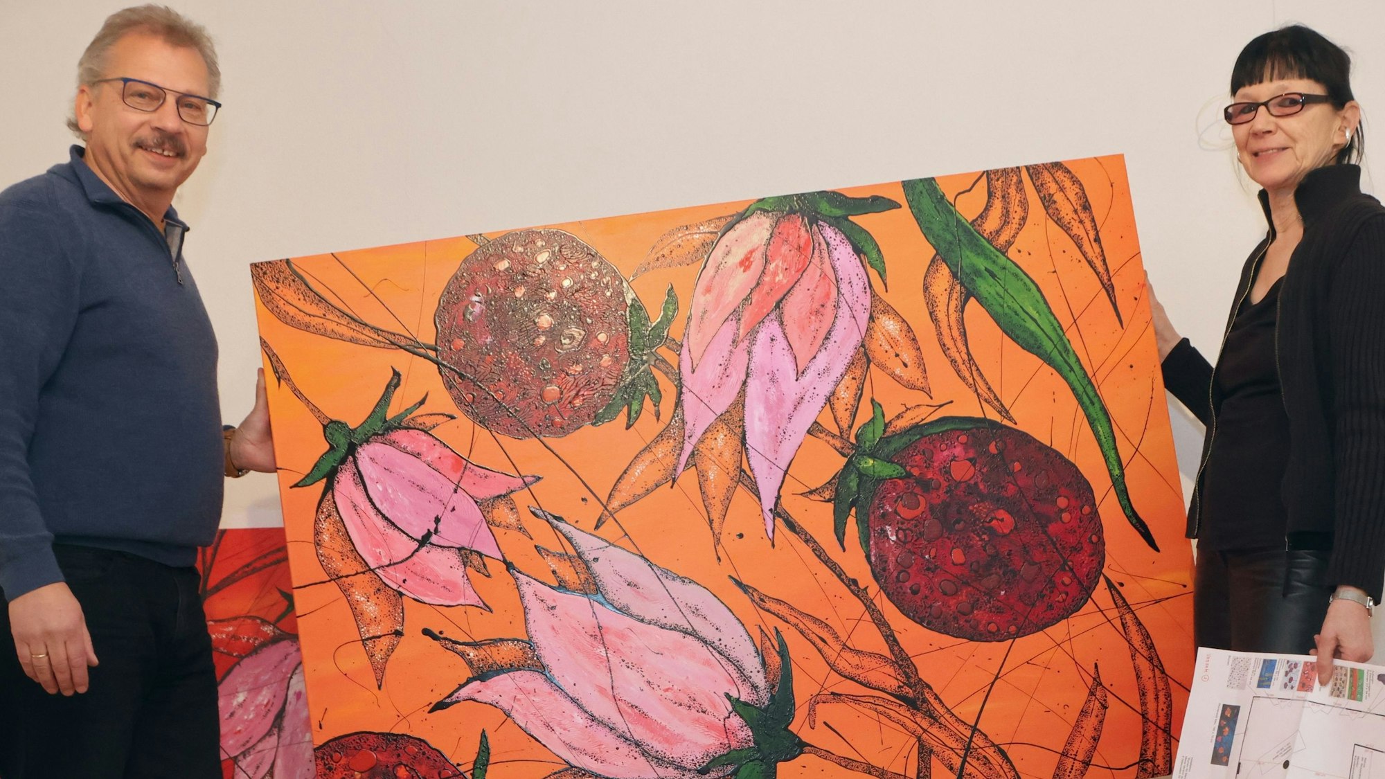 Axel Müller und Marion Menzel halten ein Gemälde im Kunstkabinett Hespert.