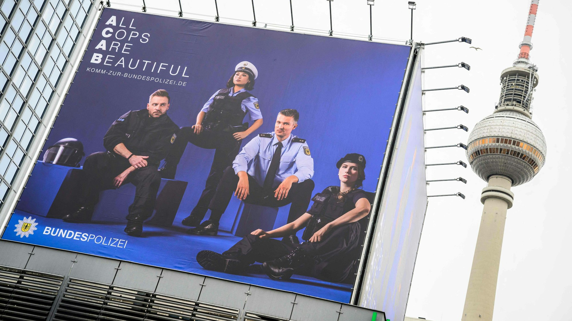 Ein „All Cops Are Beautiful“ Werbeplakat vor dem Berliner Fernsehturm.