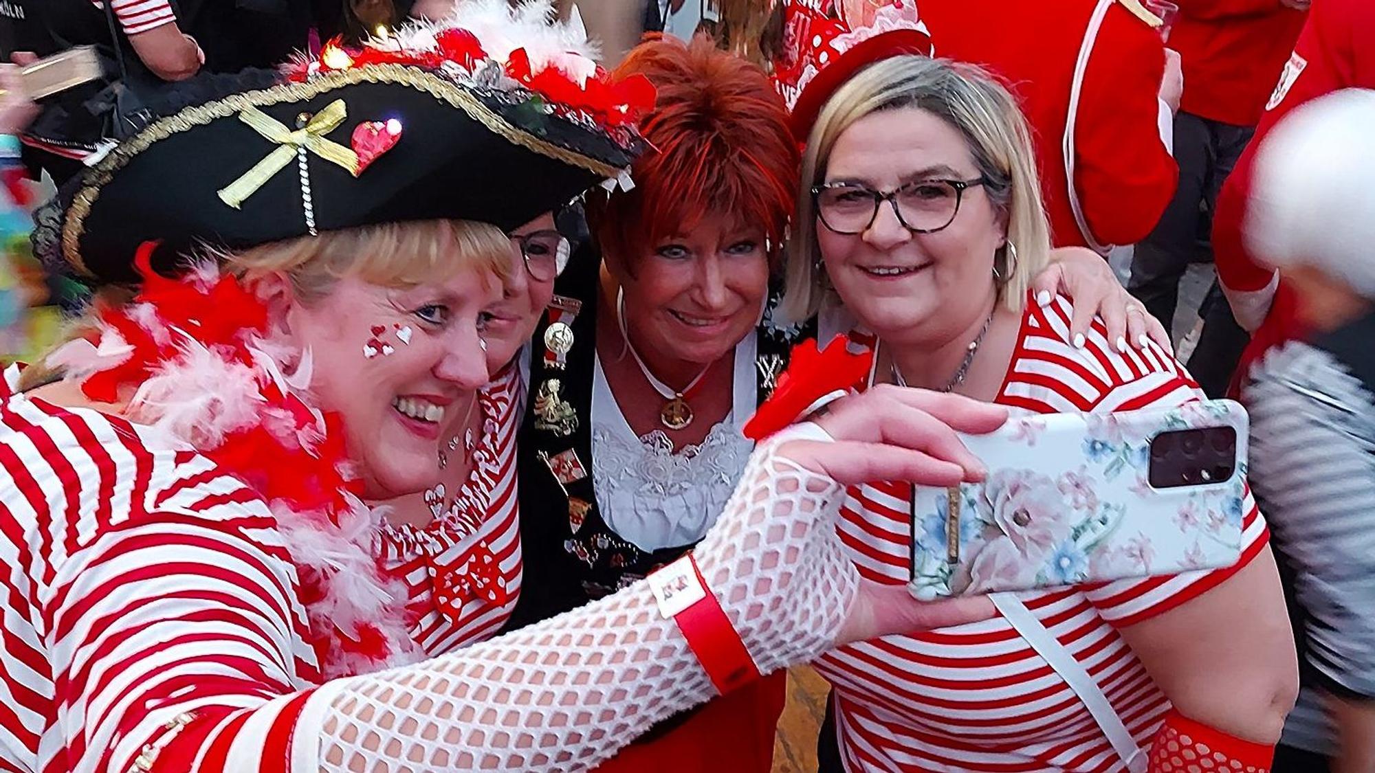 Kostümierte Fans machen mit dem Handy ein Selfie mit der Karnevalssängerin Marita Köllner (2.v.r.).