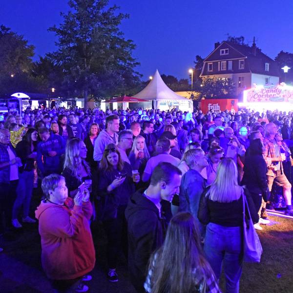 Publikum bei abendlicher Beleuchtung vor der Bühne im Stadtpark