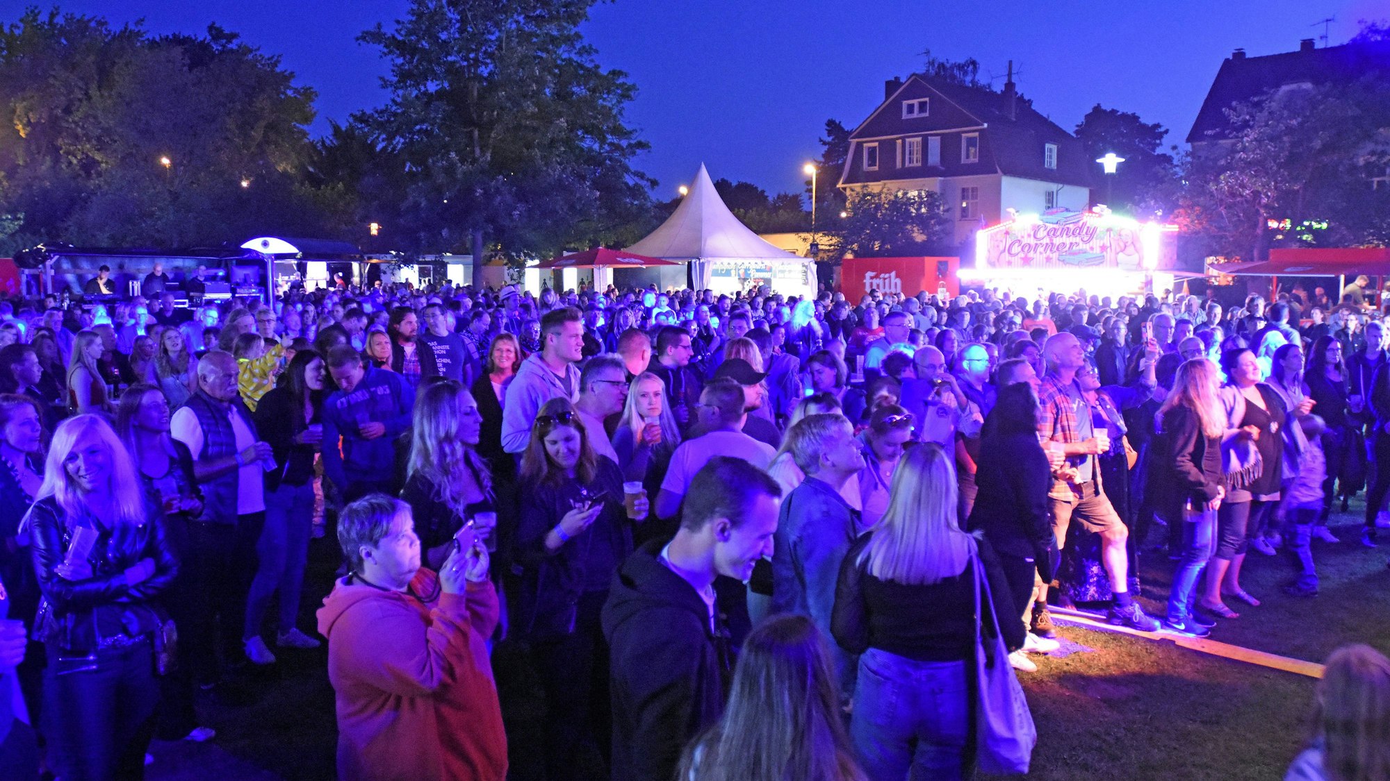 Publikum bei abendlicher Beleuchtung vor der Bühne im Stadtpark