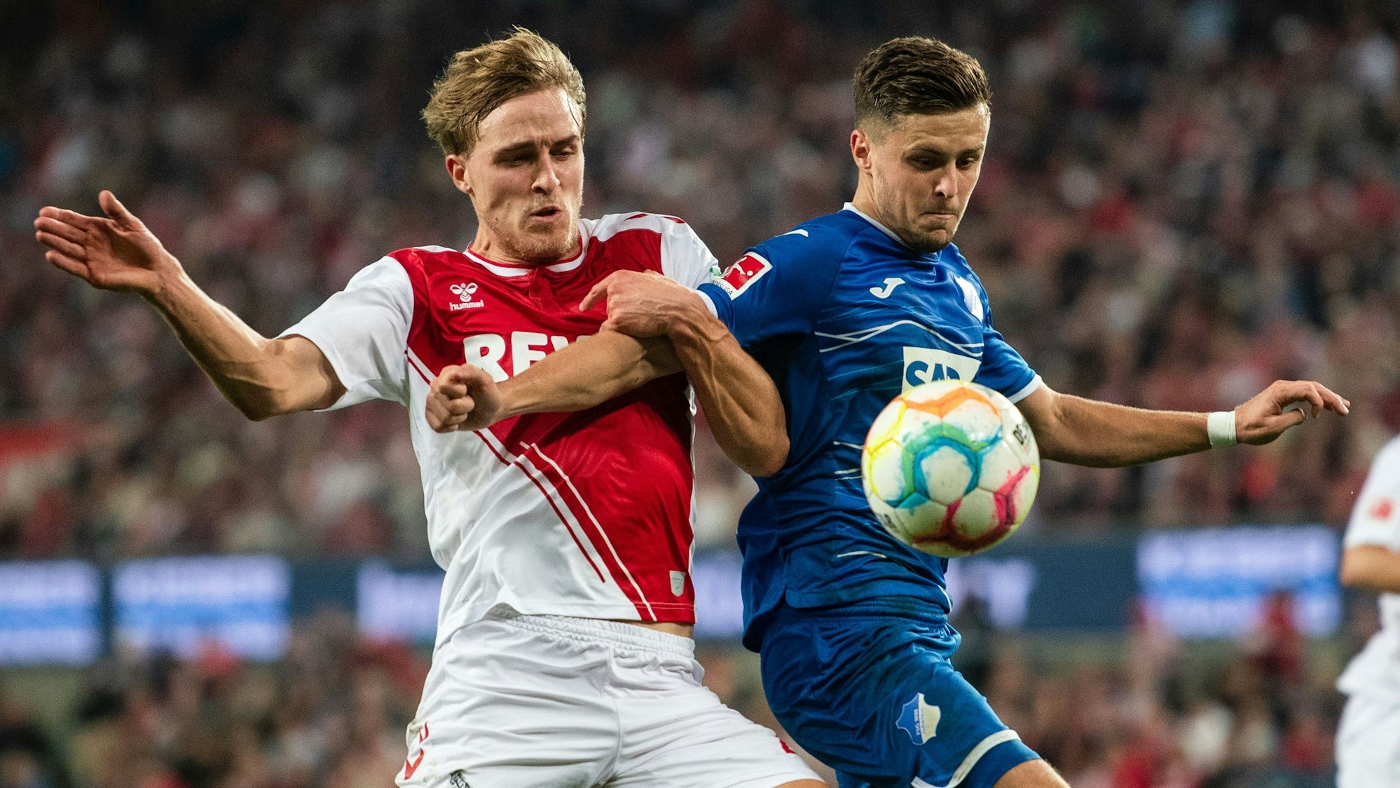 Kölns Timo Hübers (l.) und Hoffenheims Christoph Baumgartner (r.) kämpfen im Hinspiel um den Ball.