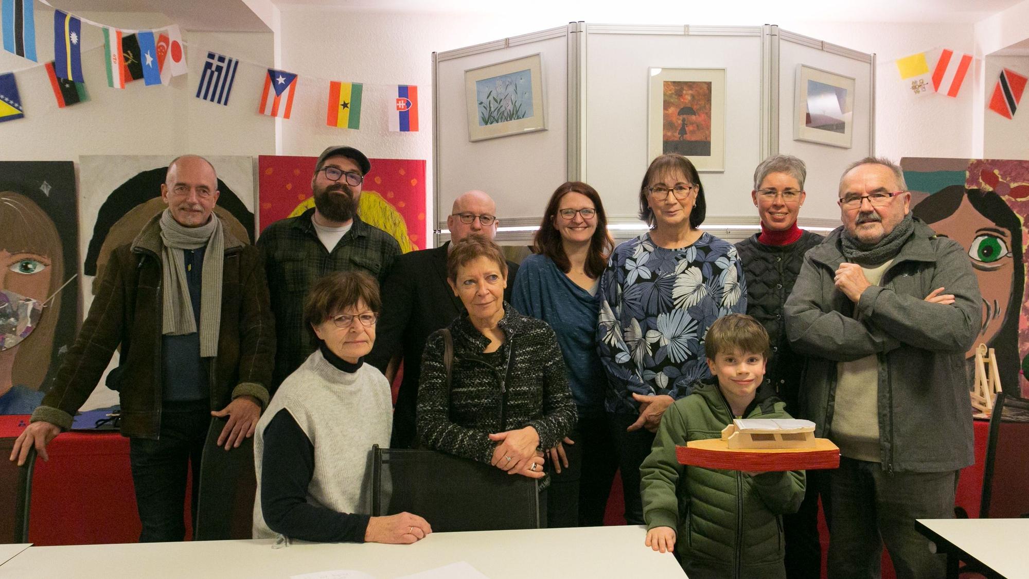 Eine Gruppen von Menschen eröffnet eine Kunstausstellung.