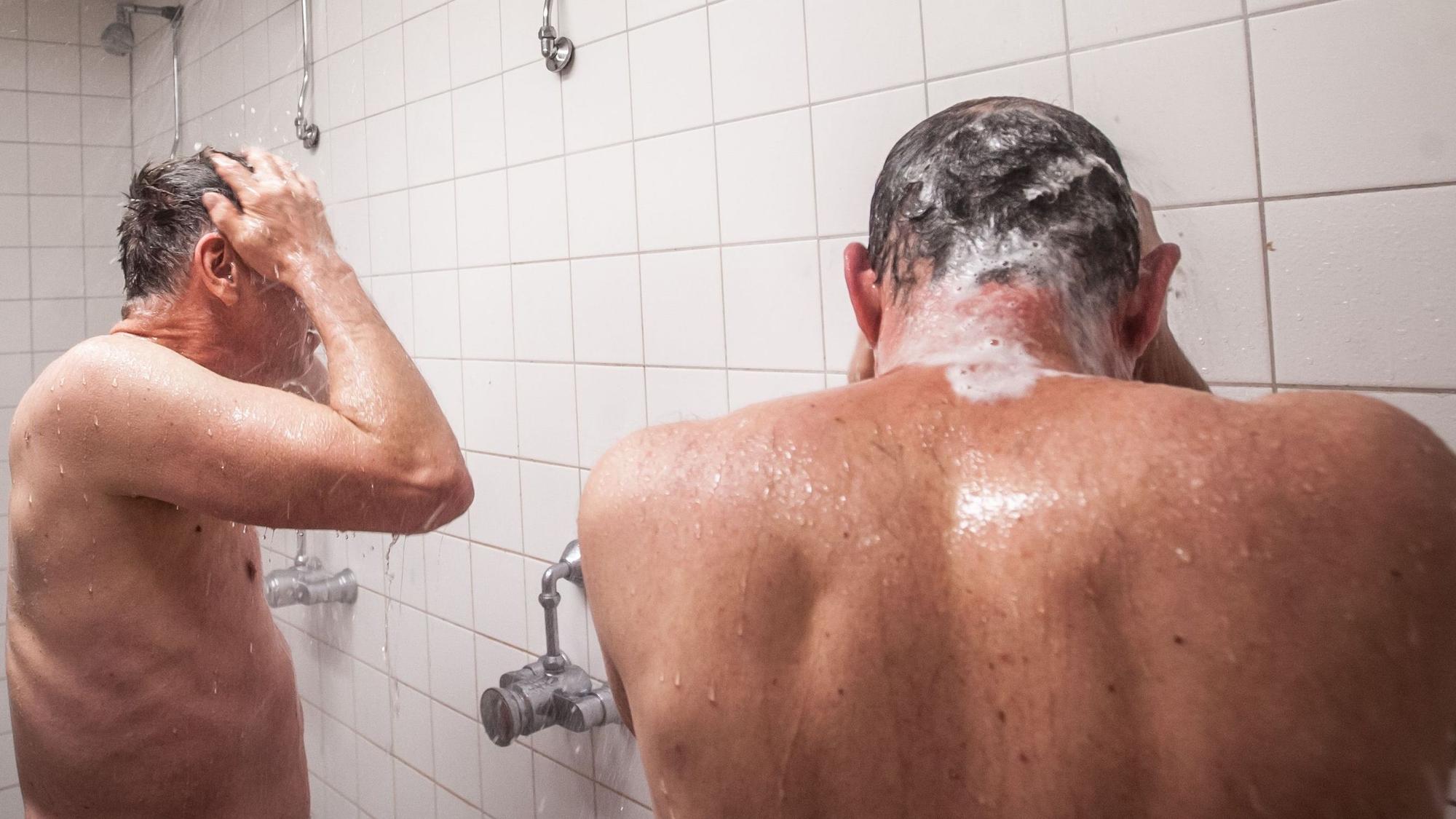 Zwei Männer in der Turnhallendusche Wolfgang-Obladen-Halle in Manfort: Duschen mit kaltem Wasser.