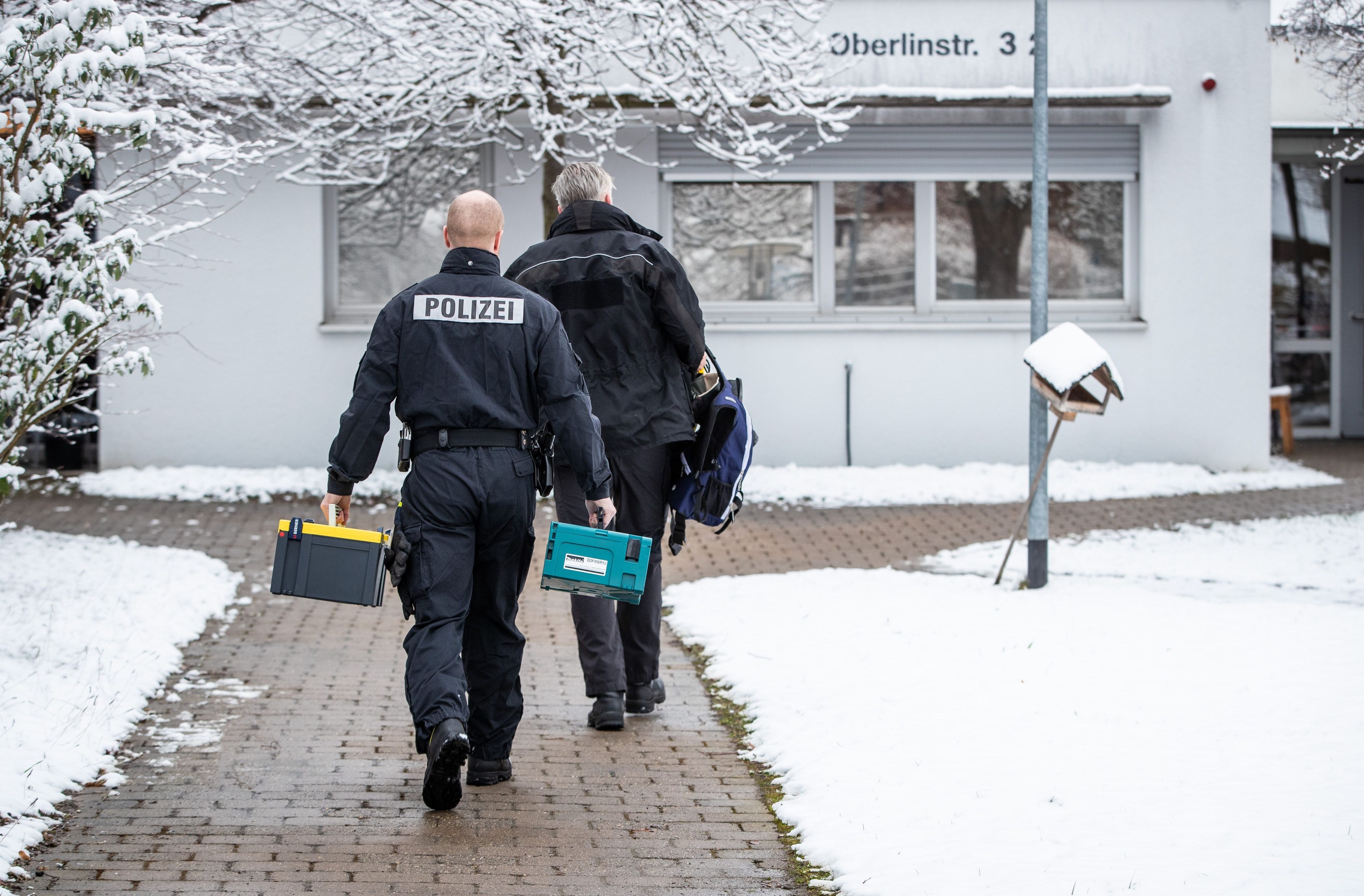 Mitarbeiter der Polizei und der Spurensicherung gehen in Richtung des Pflegeheims.