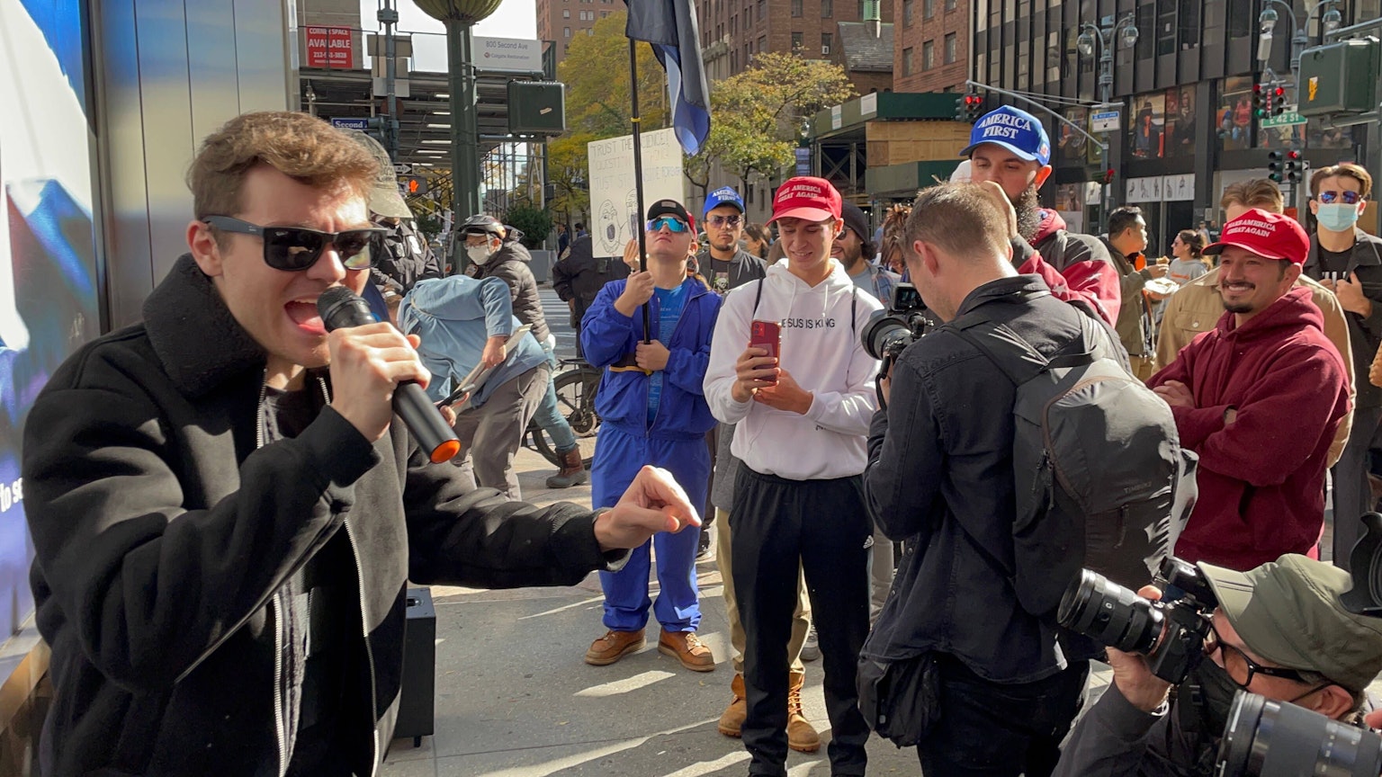 Nick Fuentes schreit bei einer Versammlung in ein Mikrofon