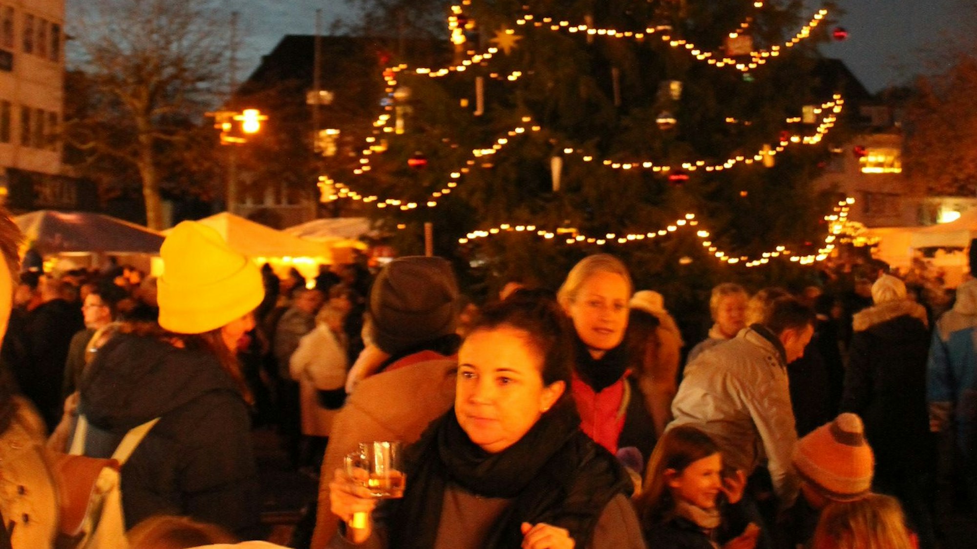 Besucher des Bratapfelfestes unterm Weihnachtsbaum auf dem Marktplatz