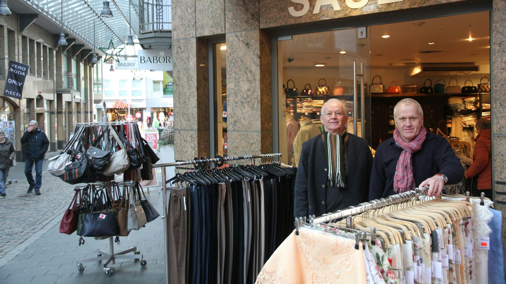 Zwei Ladenbesitzer stehen vor ihrem Geschäft.