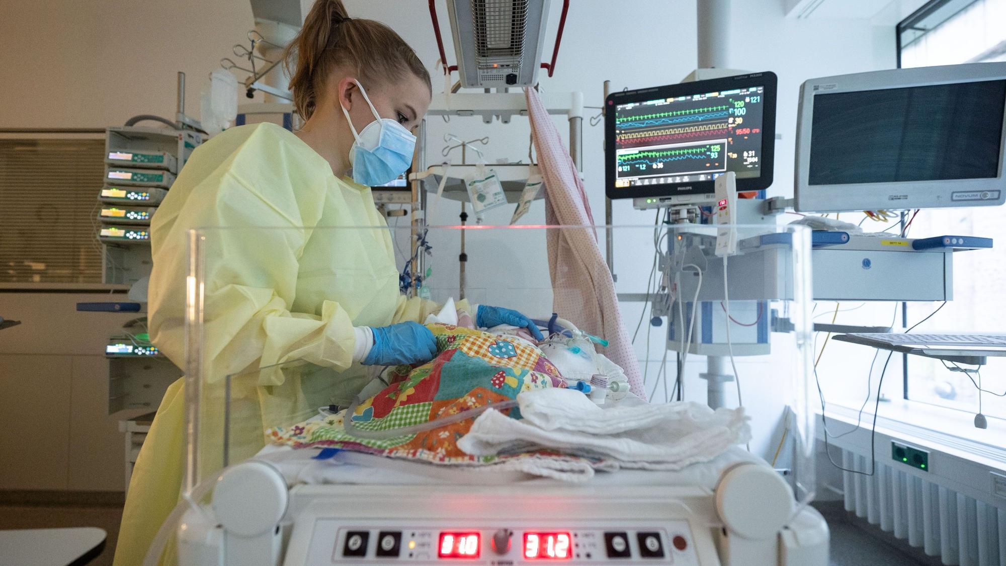 Eine Intensivpflegerin versorgt auf der Kinder-Intensivstation einen am RS-Virus erkrankten Patienten, der beatmet wird.