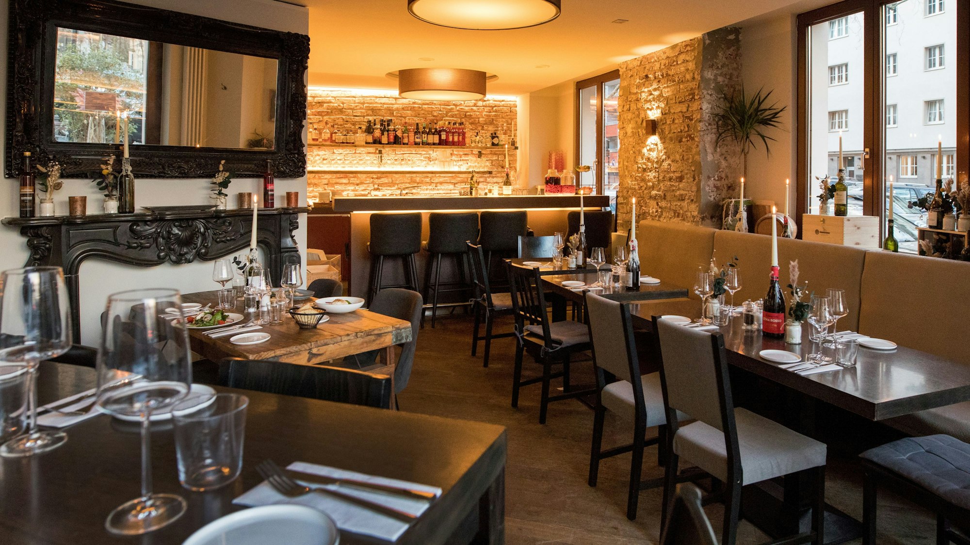 Innenraum des Restaurants Barile mit gedeckten, dunklen Holztischen