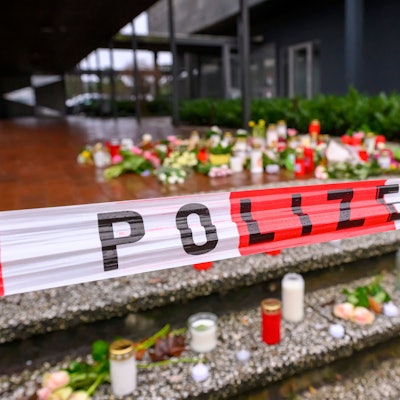 Auf einer Treppe vor dem Berufskolleg Tecklenburger Land wurden Kerzen und Blumen abgelegt. Ein Absperrband der Polizei spannt über den Stufen.