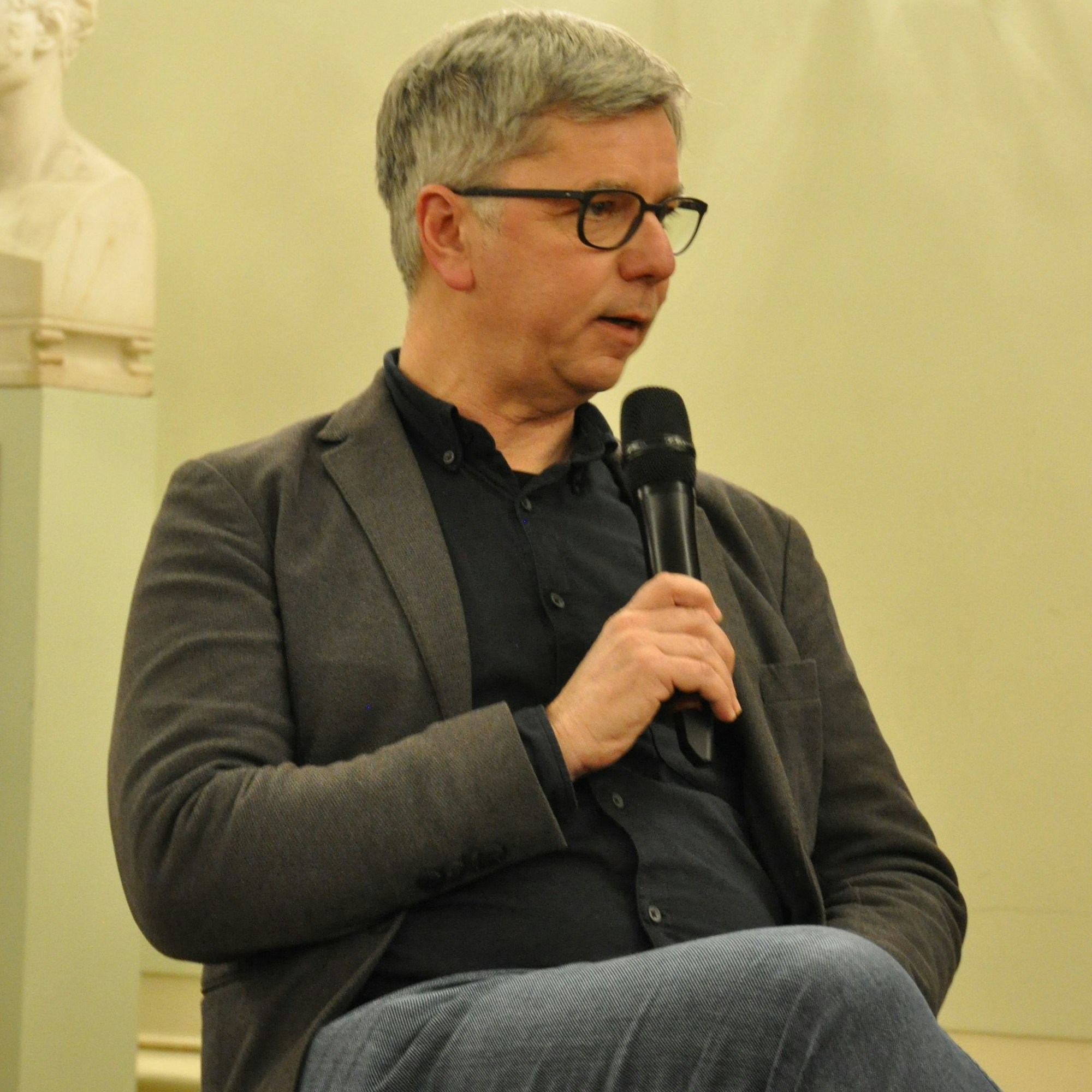 Der Freiburger Theologieprofessor Magnus Streit diskutiert mit einem Mikrofon in der Hand im Festsaal der Universität Bonn.