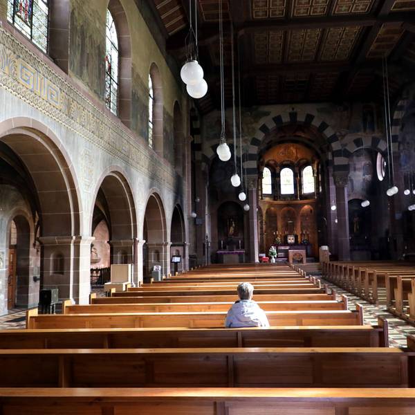 Eine Frau sitzt alleine in der Kirche St. Laurentius in Bergisch Gladbach.