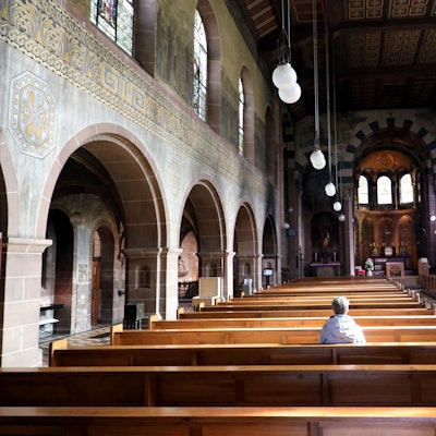 Eine Frau sitzt alleine in der Kirche St. Laurentius in Bergisch Gladbach.