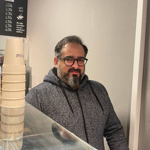 Der Besitzer von Back Löwe, Farshid Sowlati, steht hinter der Theke. Neben ihm stehen Mehrwegbecher der Kölner Firma Vytal. Seit dem 1.1.2023 müssen Gastronomen Mehrwegbehälter zum Mitnehmen anbieten, die nicht teuerer sein dürfen als Einwegverpackungen.