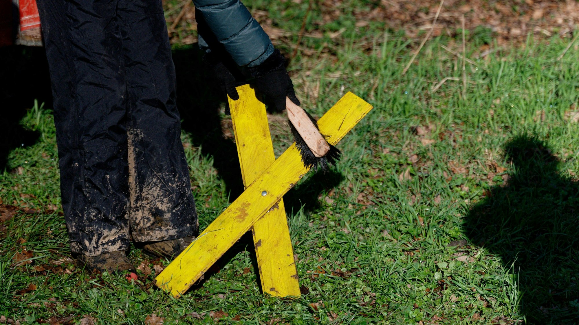 Eine Aktivistin reinigt vor einer Pressekonferenz zu den Protesten in Lützerath in Keyenberg ein Gelbes Kreuz.