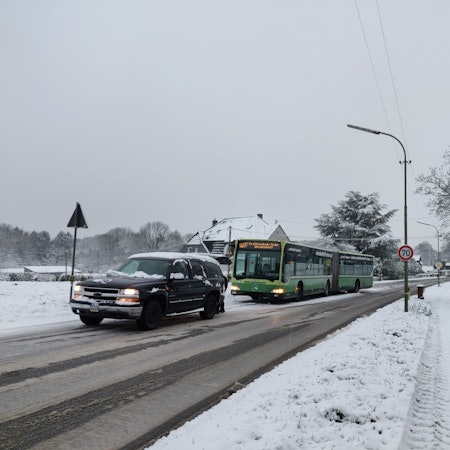 Schnee in Abschleppversuch eines liegengebliebenen Busses auf der L294. Dahinter stauen sich Lastwagen und Autos.und Witzhelden