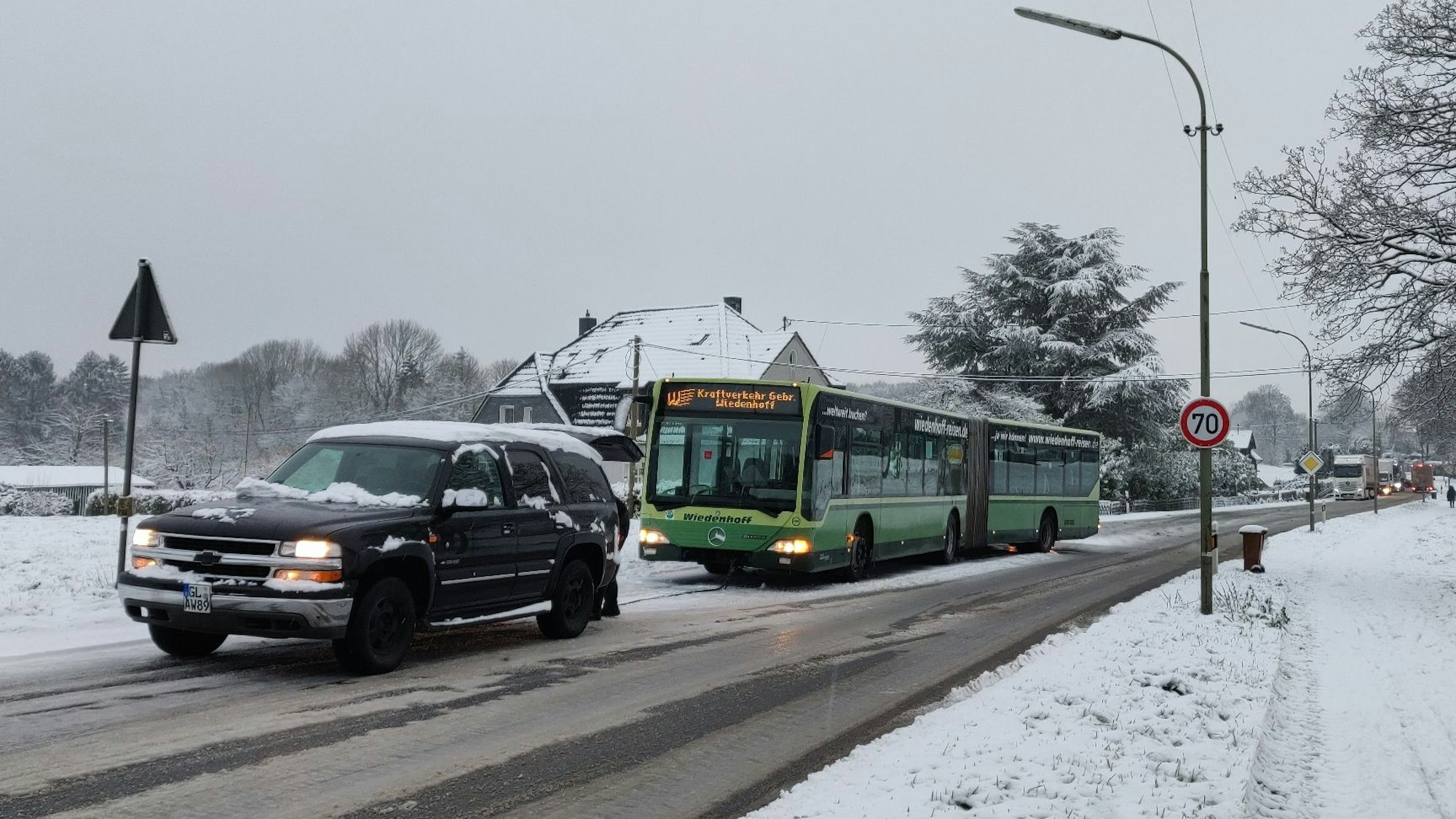 Schnee in Abschleppversuch eines liegengebliebenen Busses auf der L294. Dahinter stauen sich Lastwagen und Autos.und Witzhelden