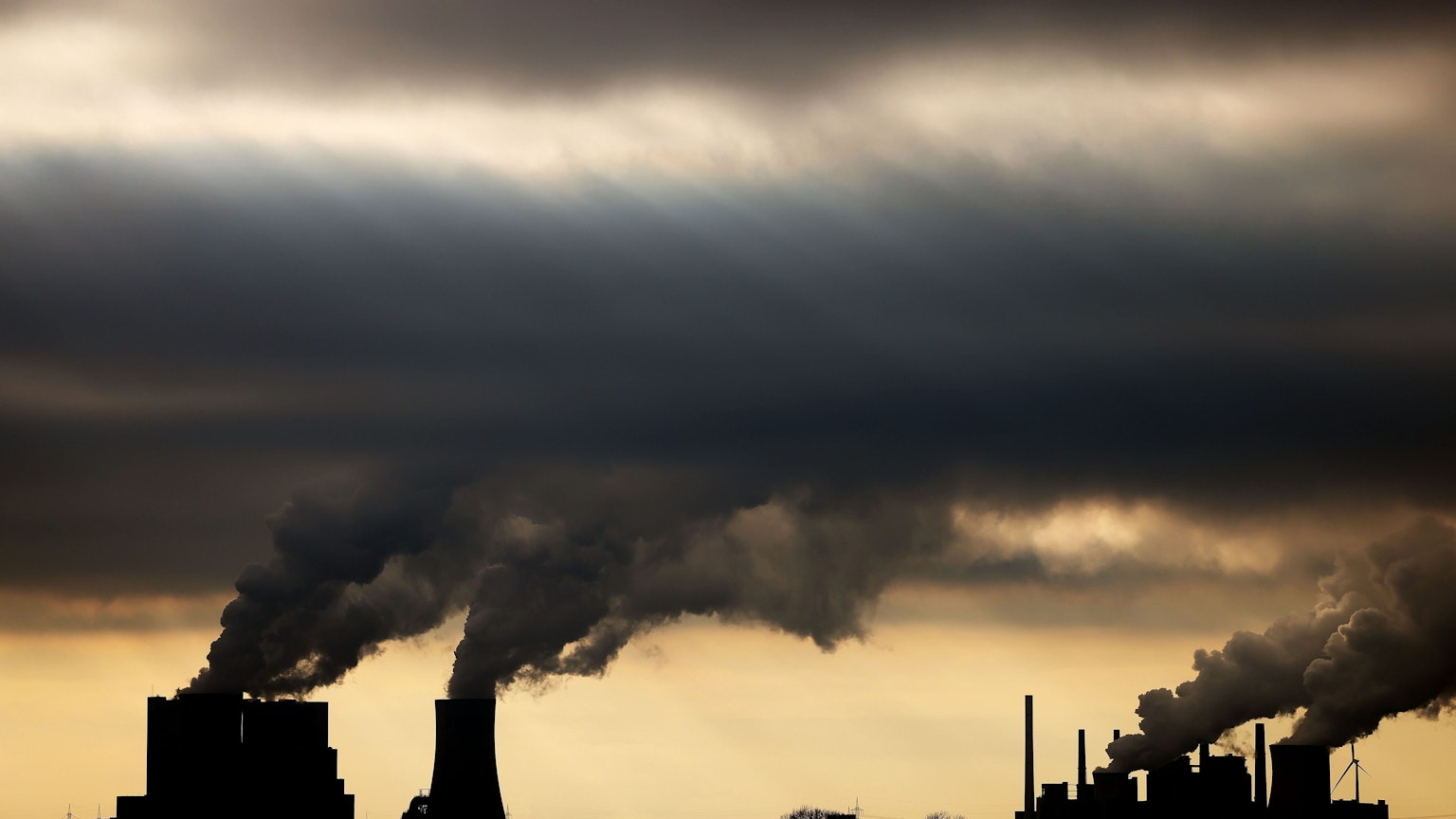 Dampf und Rauch steigt im Gegenlicht aus den Braunkohlekraftwerken Neurath II (l) und Neurath I bei Grevenbroich auf.