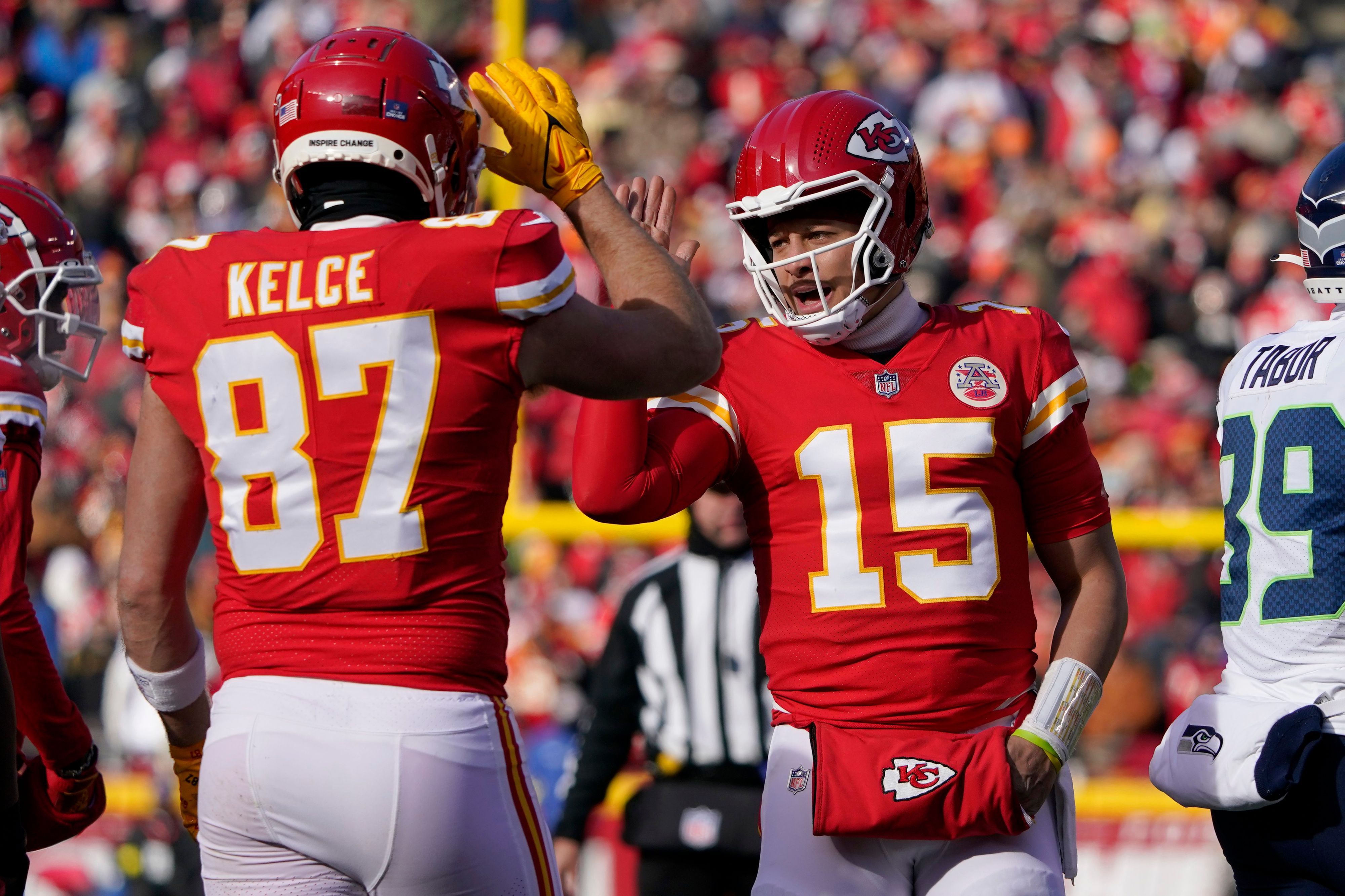 Kansas City Chiefs quarterback Patrick Mahomes (15) and tight end Travis Kelce (87) celebrate during the first half of an NFL football game against the Seattle Seahawks Saturday, Dec. 24, 2022, in Kansas City, Mo. (AP Photo/Ed Zurga)