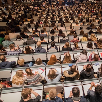 Studenten verfolgen im Hörsaal im Hauptgebäude der Universität zu Köln die Erstsemesterbegrüßung.