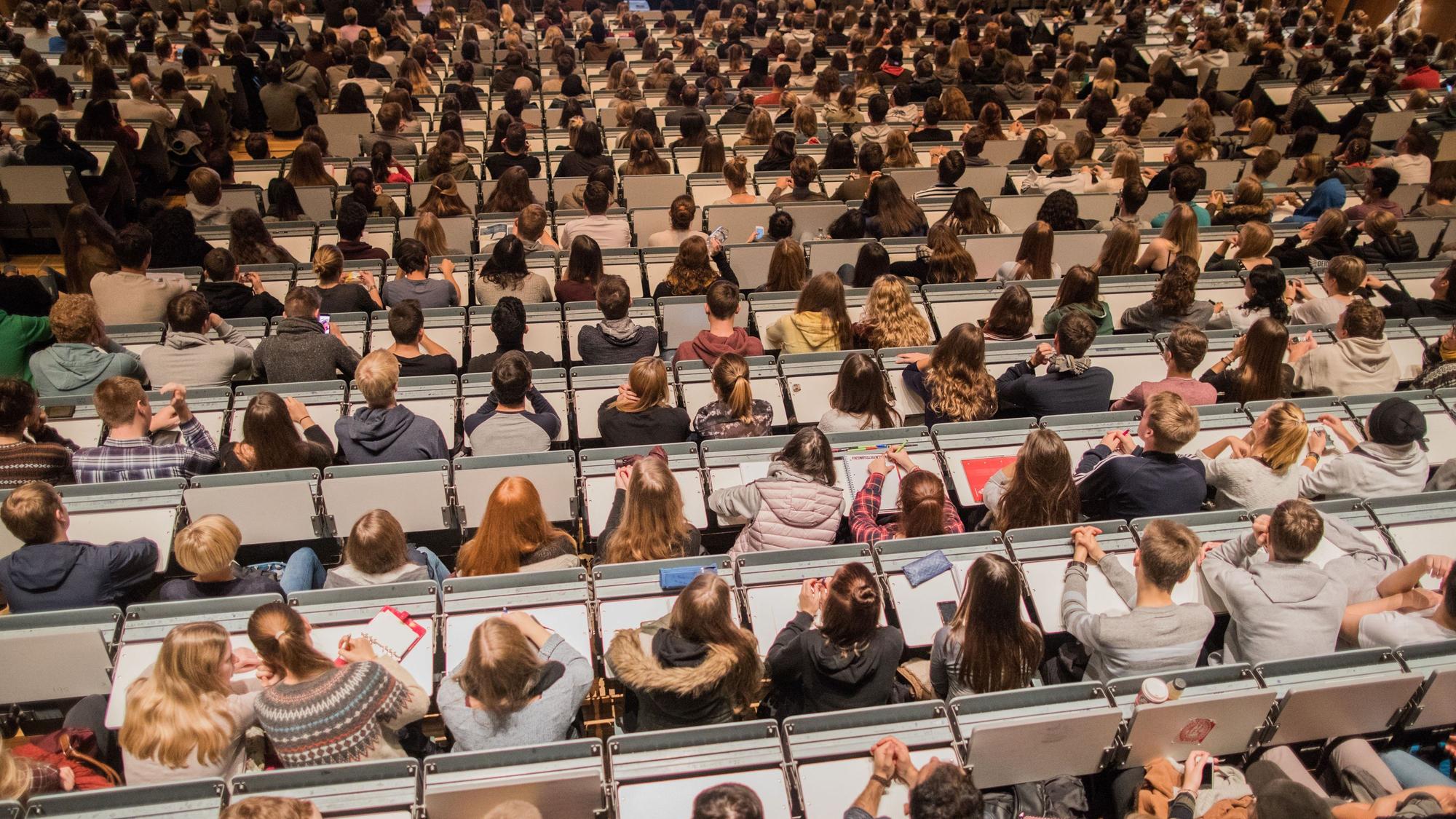 ARCHIV - Studenten verfolgen am 09.10.2017 im Hörsaal im Hauptgebäude der Universität zu Köln in Köln (Nordrhein-Westfalen) die Erstsemesterbegrüßung.