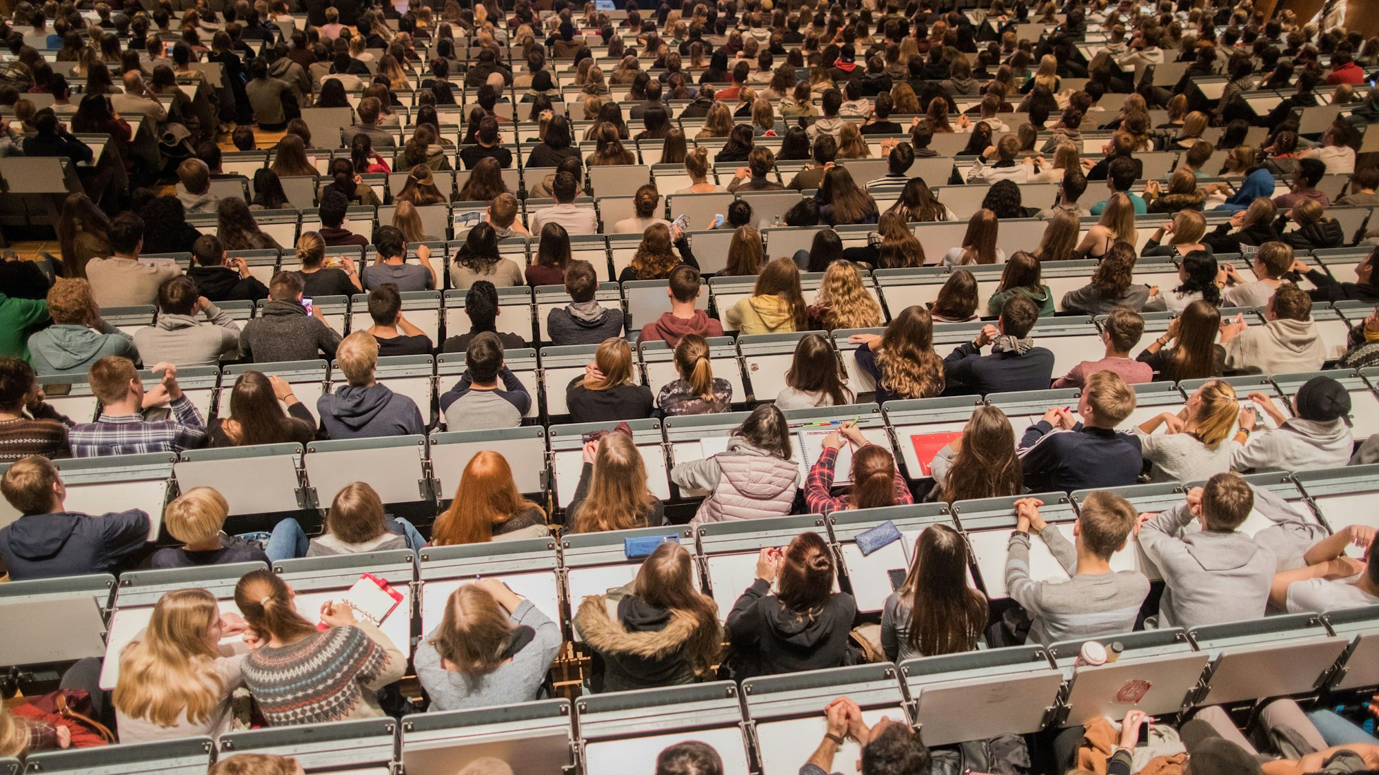 ARCHIV - Studenten verfolgen am 09.10.2017 im Hörsaal im Hauptgebäude der Universität zu Köln in Köln (Nordrhein-Westfalen) die Erstsemesterbegrüßung.