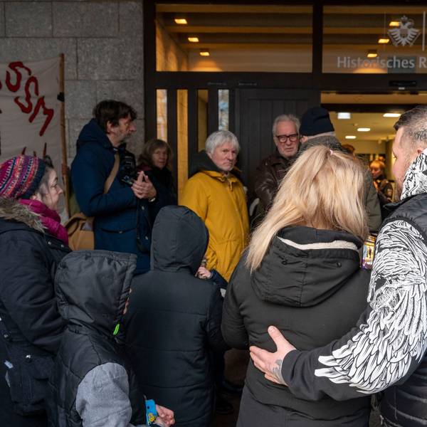 Die von der Räumung betroffene Familie steht vor dem Eingang des Kölner Rathauses.