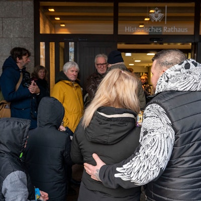 Die von der Räumung betroffene Familie steht vor dem Eingang des Kölner Rathauses.