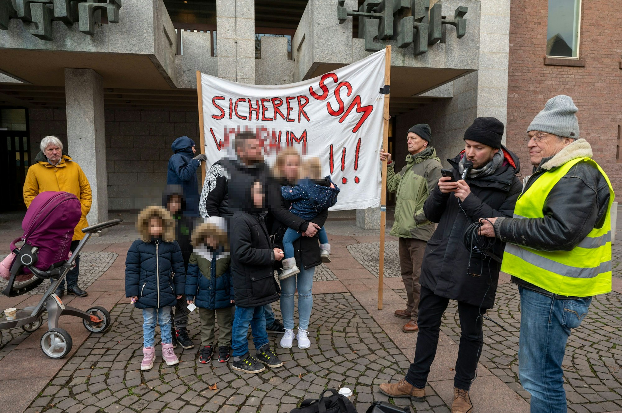 Familie W. steht während einer Protestkundgebung vor dem Kölner Rathaus.