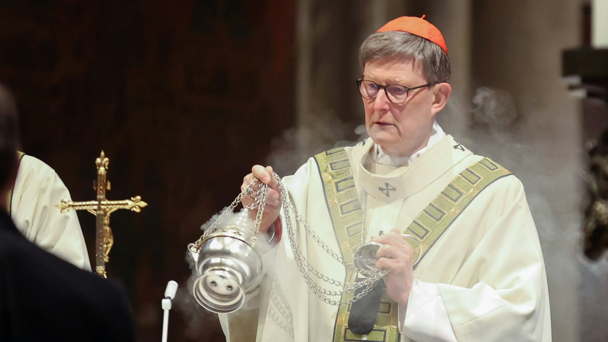 Kardinal Woelki schwenkt Weihrauch während der Messe im Kölner Dom.