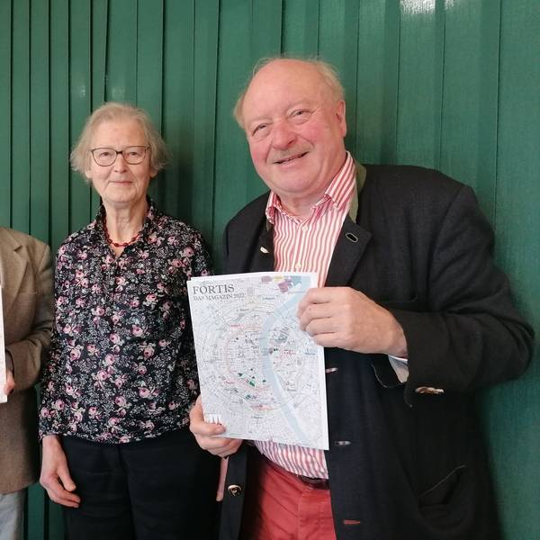 Alexander Hess, Henriette Meynen und Konrad Adenauer mit dem Magazin in der Hand vor einer grünen Wand.