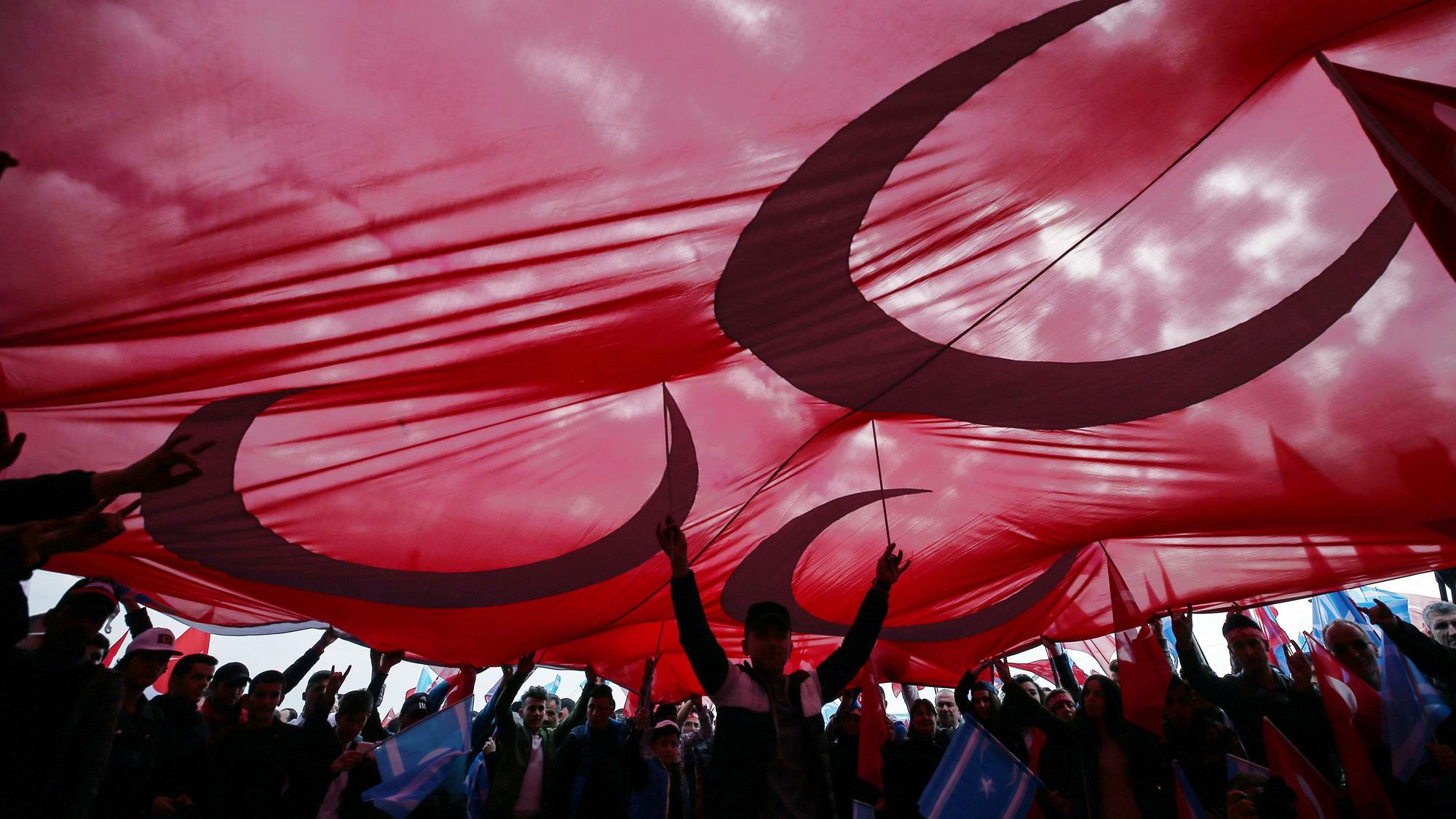 Anhänger der nationalistischen Partei jubeln 2017 bei einer Veranstaltung zur Unterstützung der Regierungspartei AKP in Istanbul unter einer großen Fahne.
