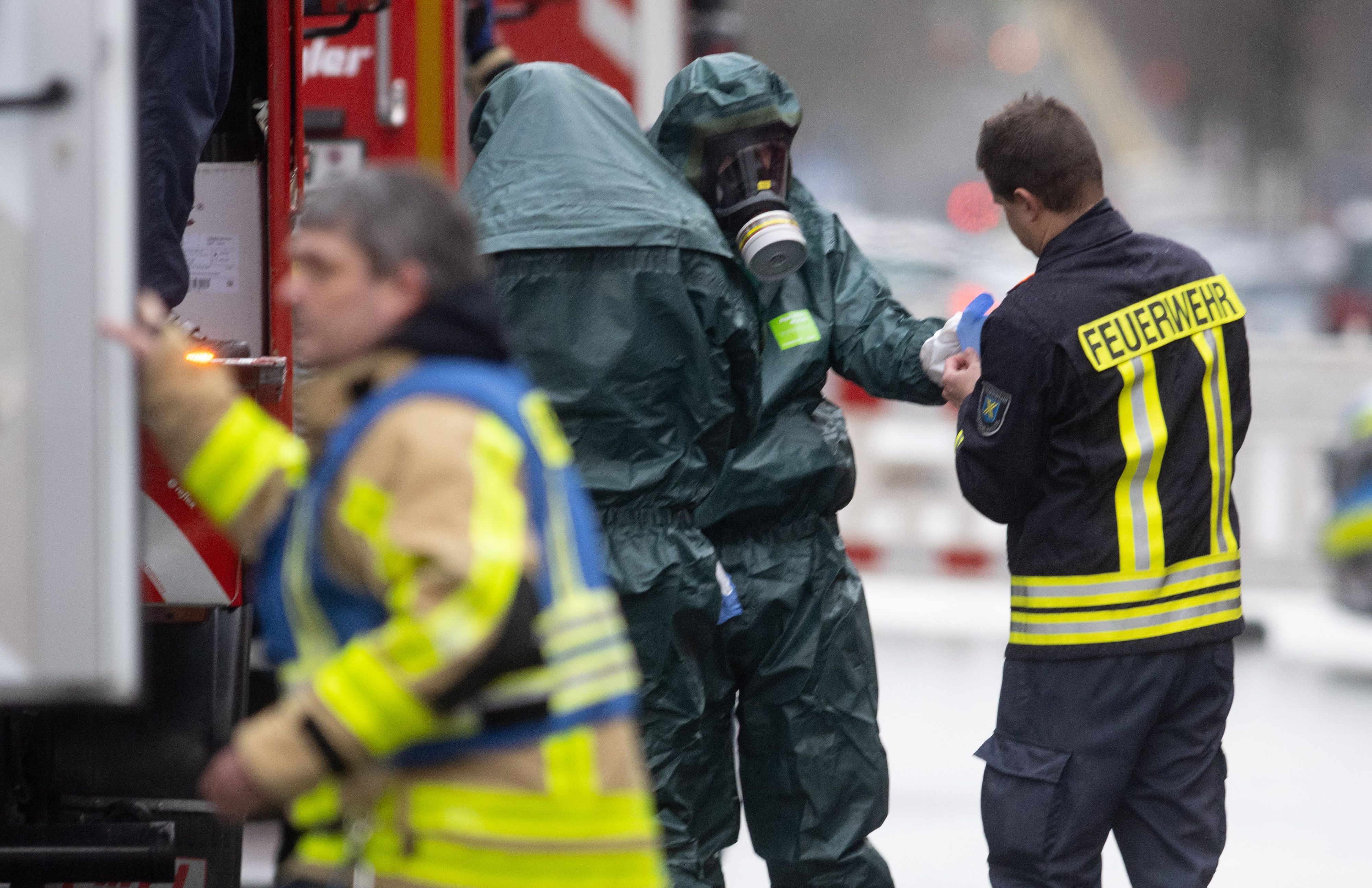 Spezialkräfte der Feuerwehr in Schutzanzügen kommen von ihrem Einsatz. Ein Iraner soll einen Giftanschlag geplant haben. Der 32-jährige und sein Bruder waren in der Nacht zum Sonntag bei einem Großeinsatz der Polizei festgenommen worden.