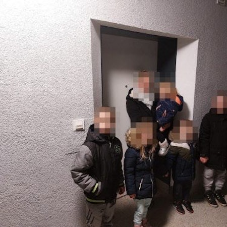 Familie W. steht mit ihren fünf Kindern im Dunkeln vor der Wohnng.