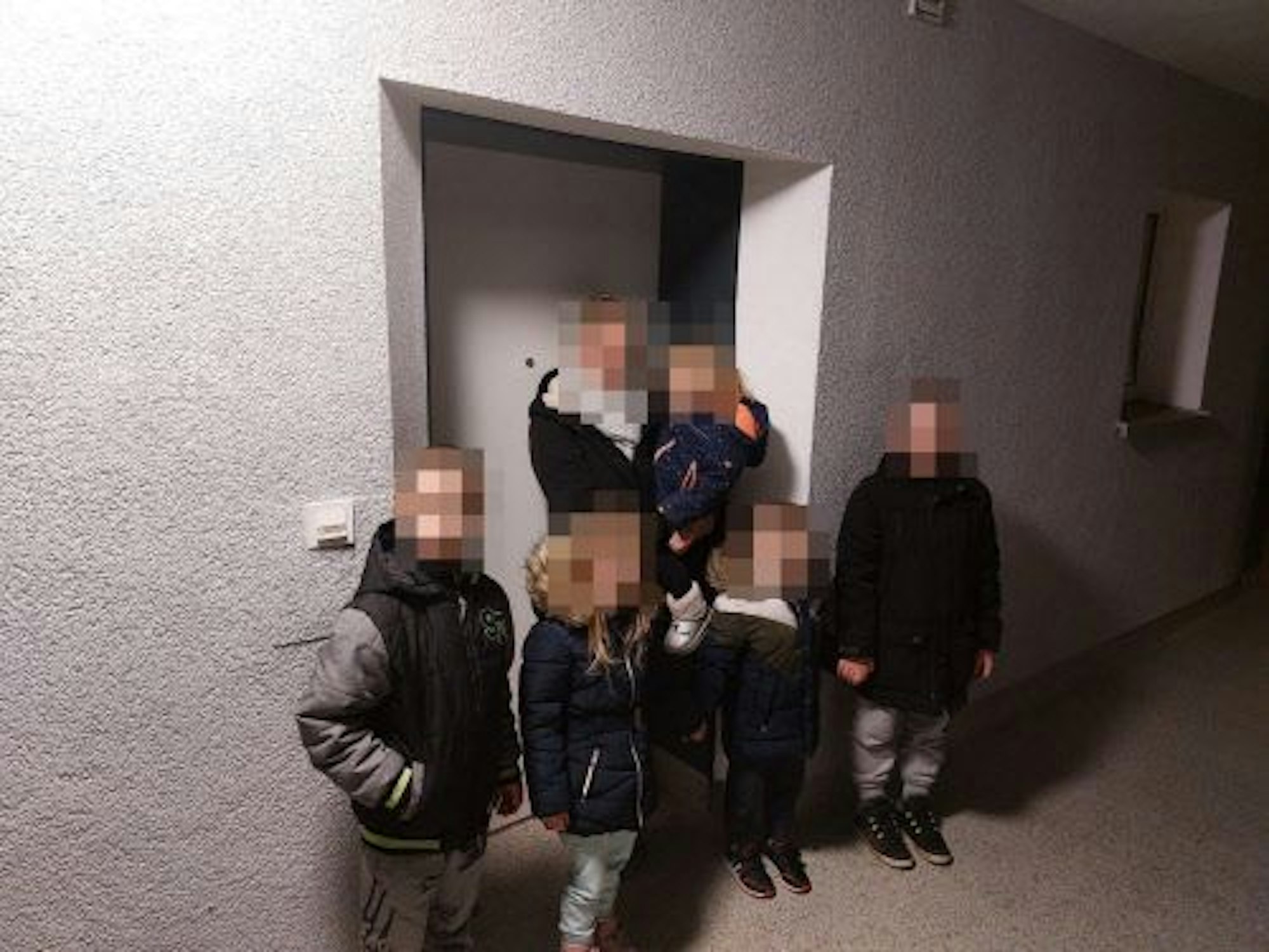 Familie W. steht mit ihren fünf Kindern im Dunkeln vor der Wohnng.