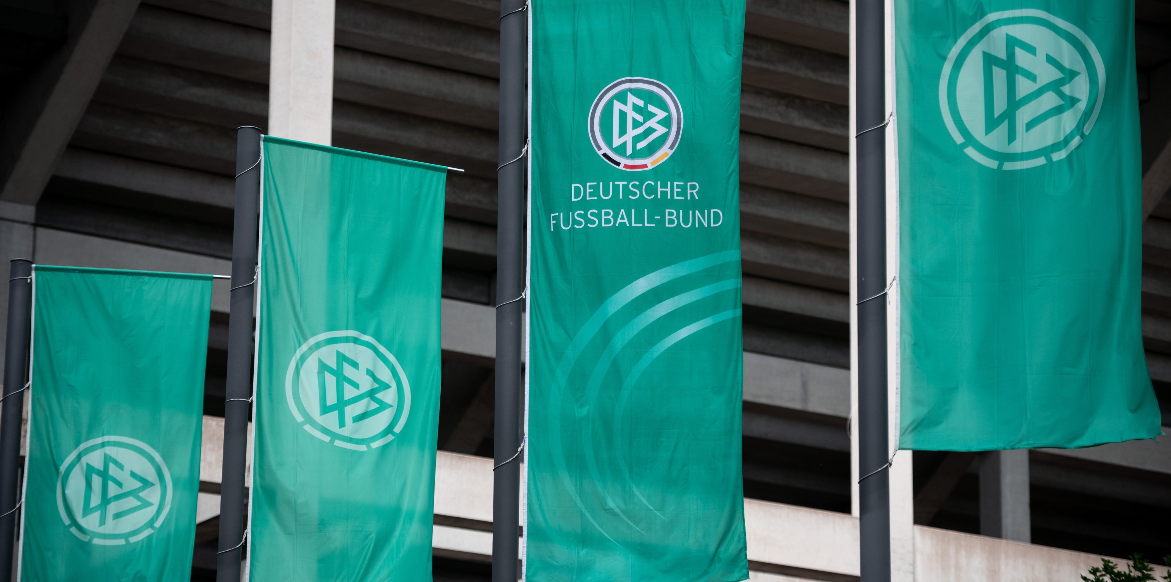 Fahnen mit dem Logo des Deutschen Fussball-Bund (DFB) wehen vor dem Stadion.