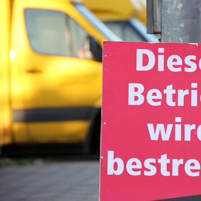 Ein Schild mit der Aufschrift „Dieser Betrieb wird bestreikt“ steht vor einer bestreikten Deutsche-Post-DHL-Niederlassung. (Archivbild)